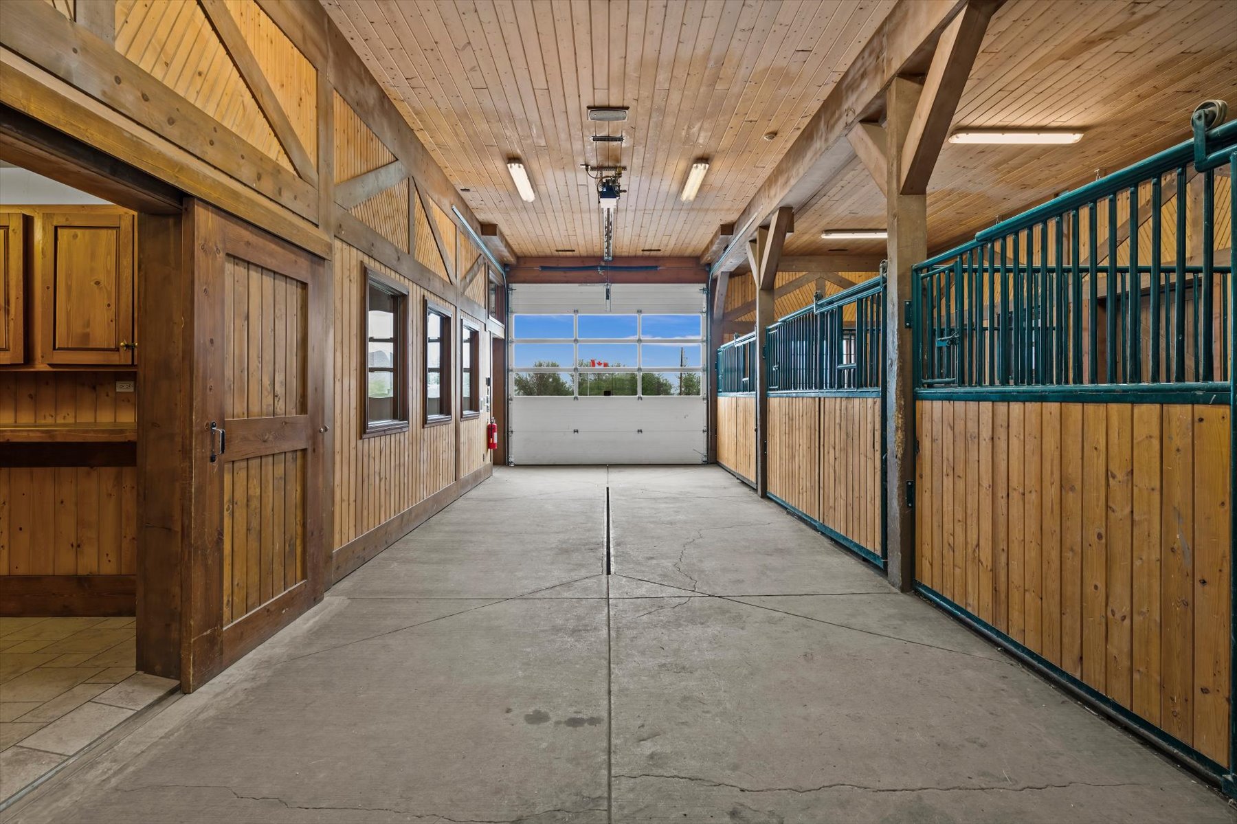 Timber-frame eight-stall aisle with green steel grilles