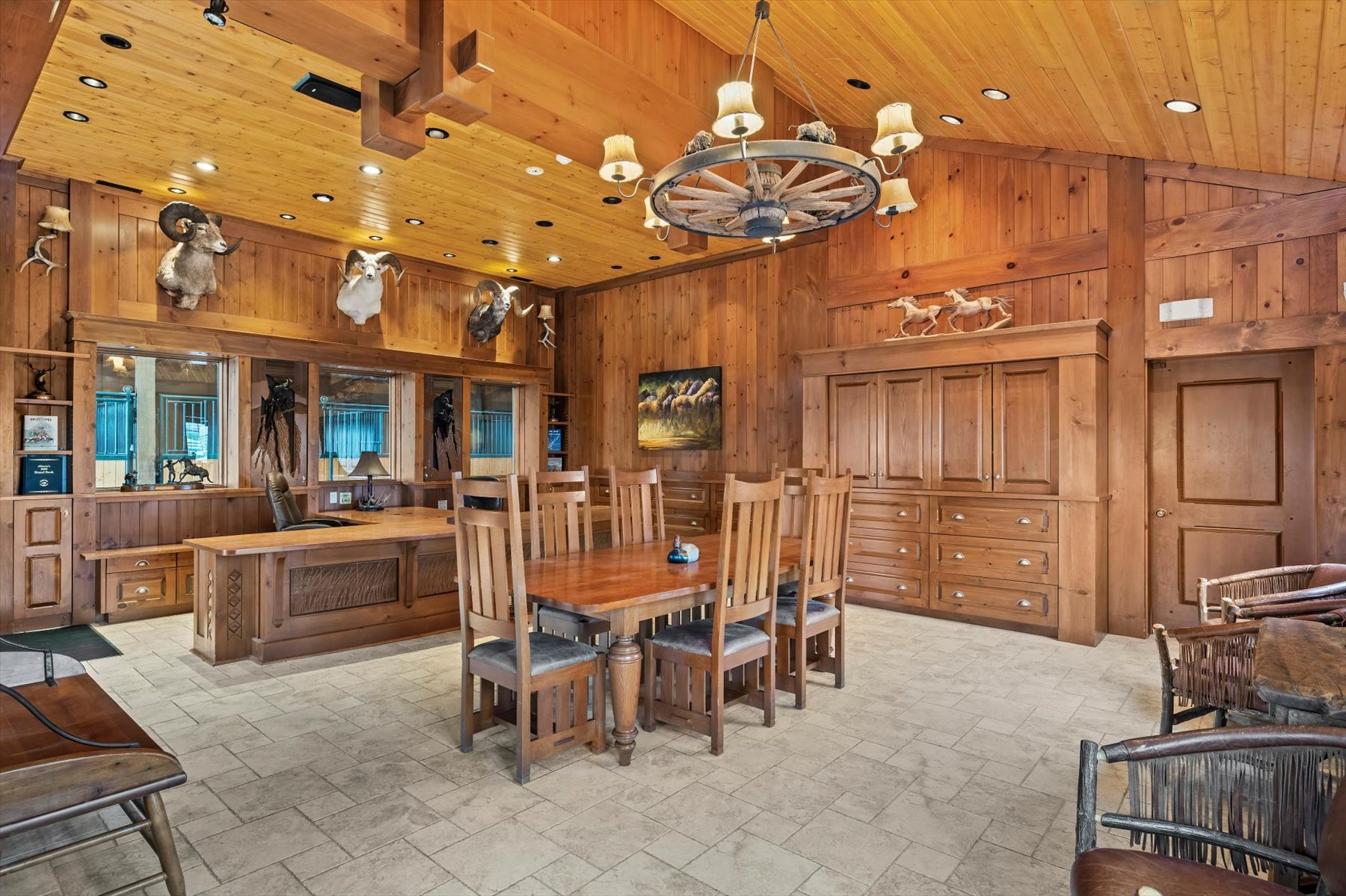 Vaulted cedar dining hall with wagon-wheel chandelier and trophy mounts